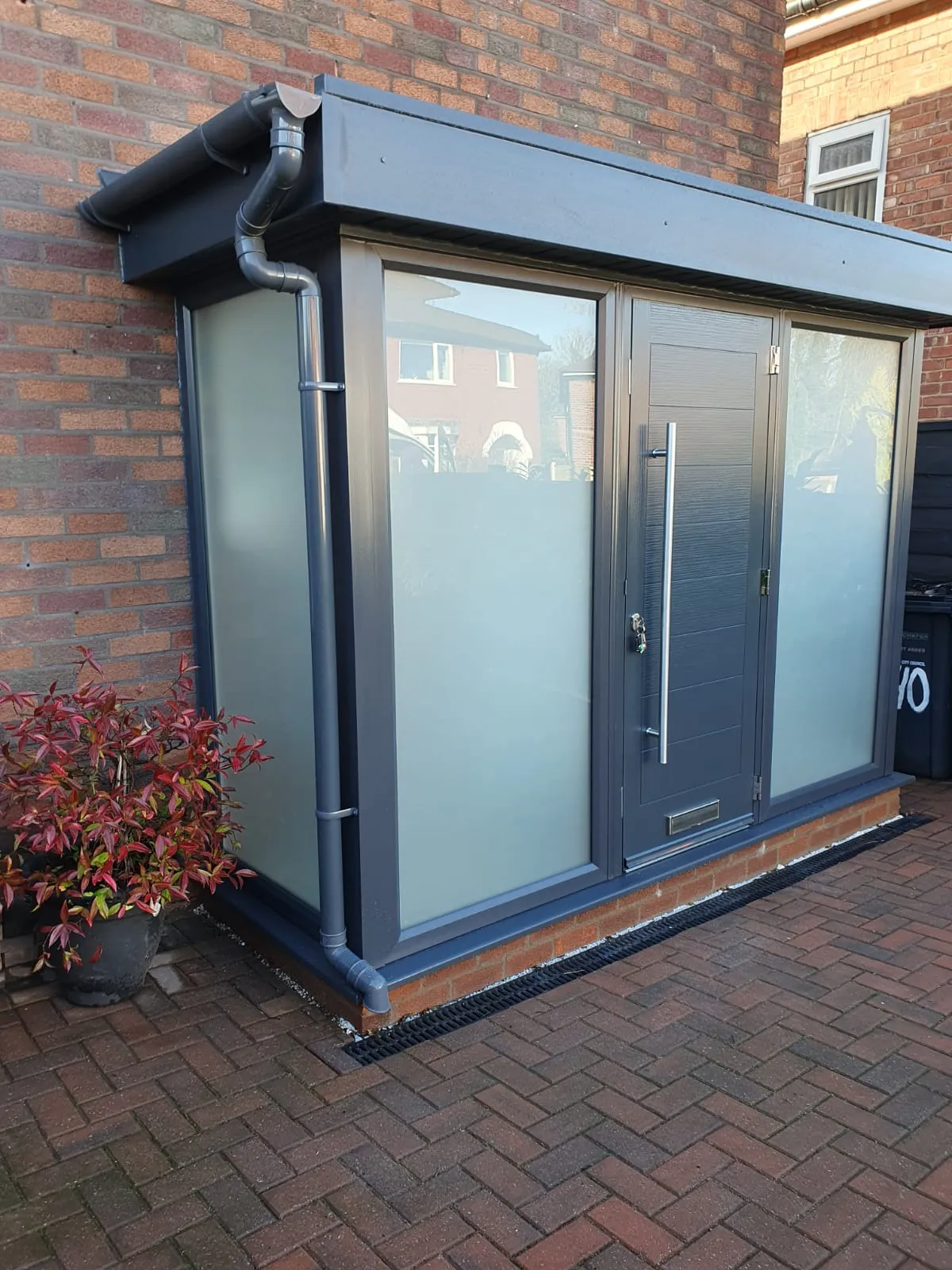 Anthracite grey porch extension with frosted glass panels and a composite door