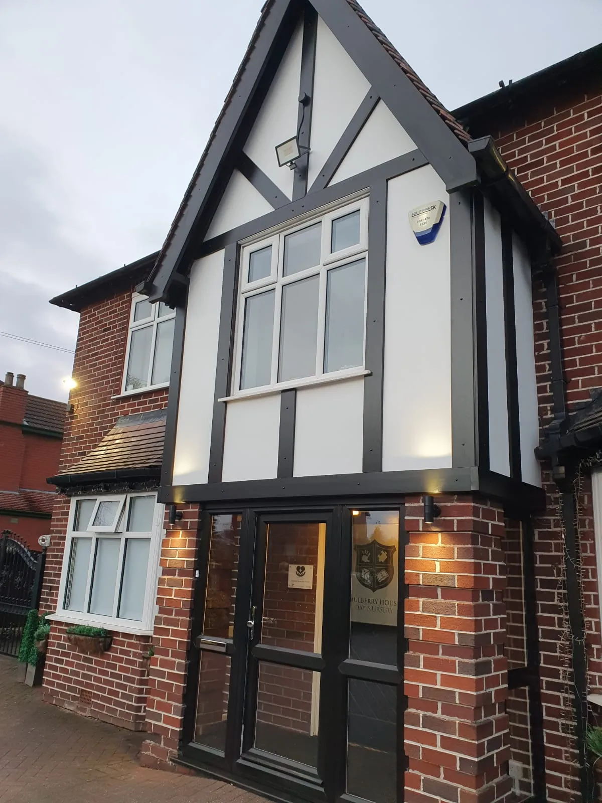Tudor-style property with grey and white PVC casement windows and glazed entrance