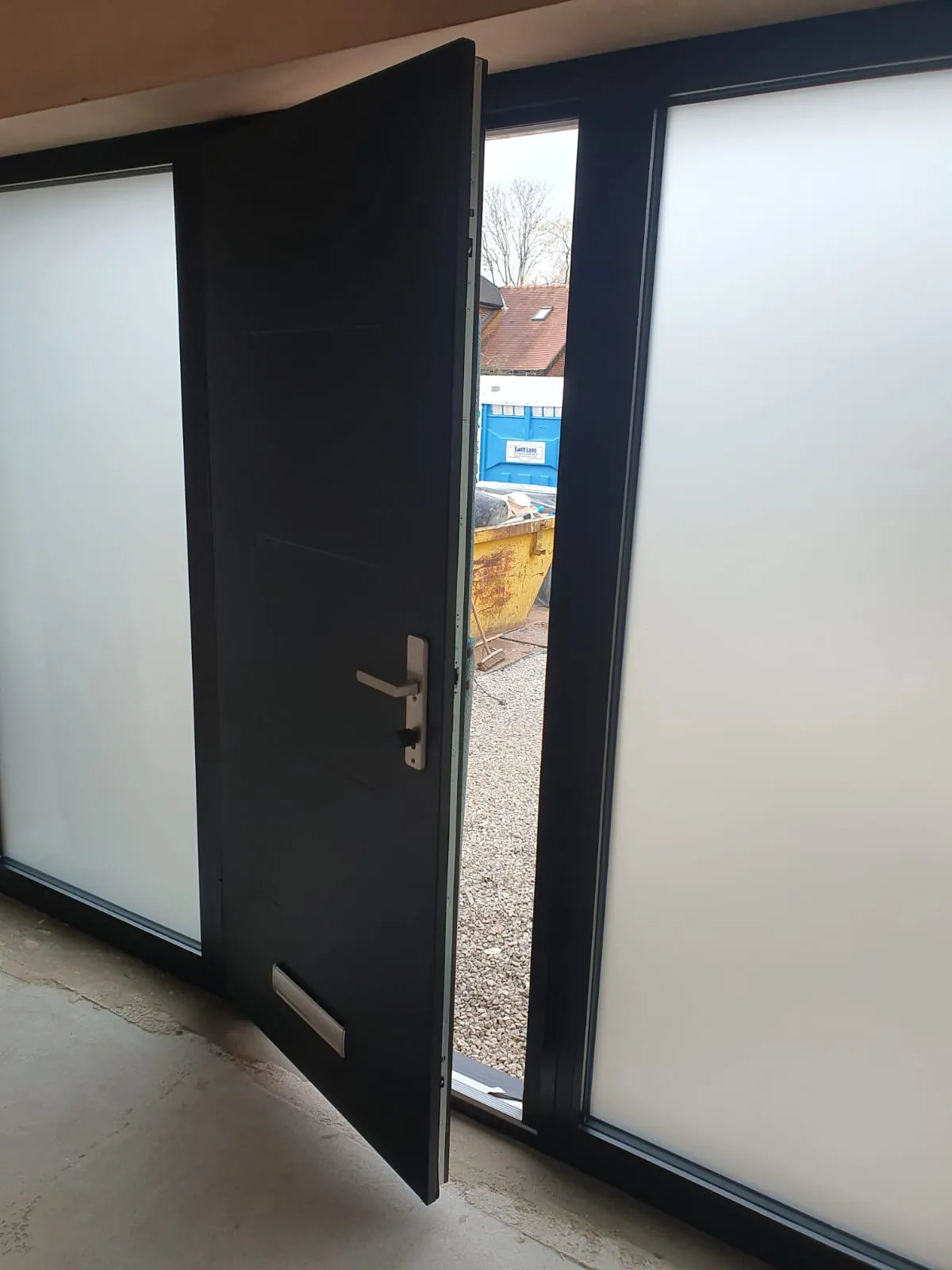 Anthracite grey modern front door with frosted sidelights and stainless steel handle