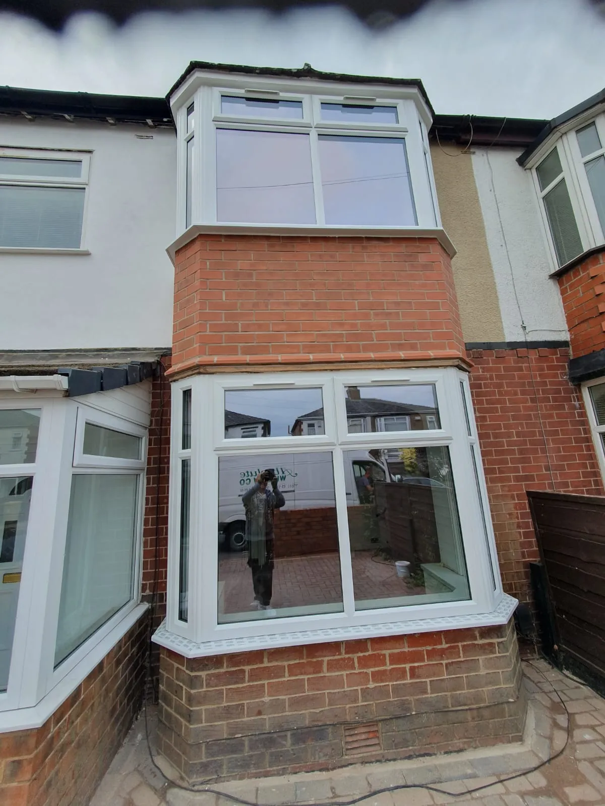 White PVC bay windows on a terraced house front in Greater Manchester