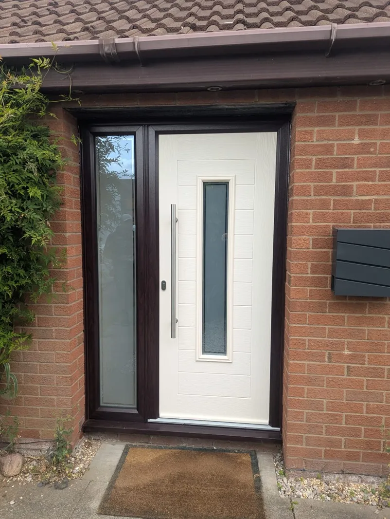 Cream composite front door with long bar handle in a rosewood-effect frame