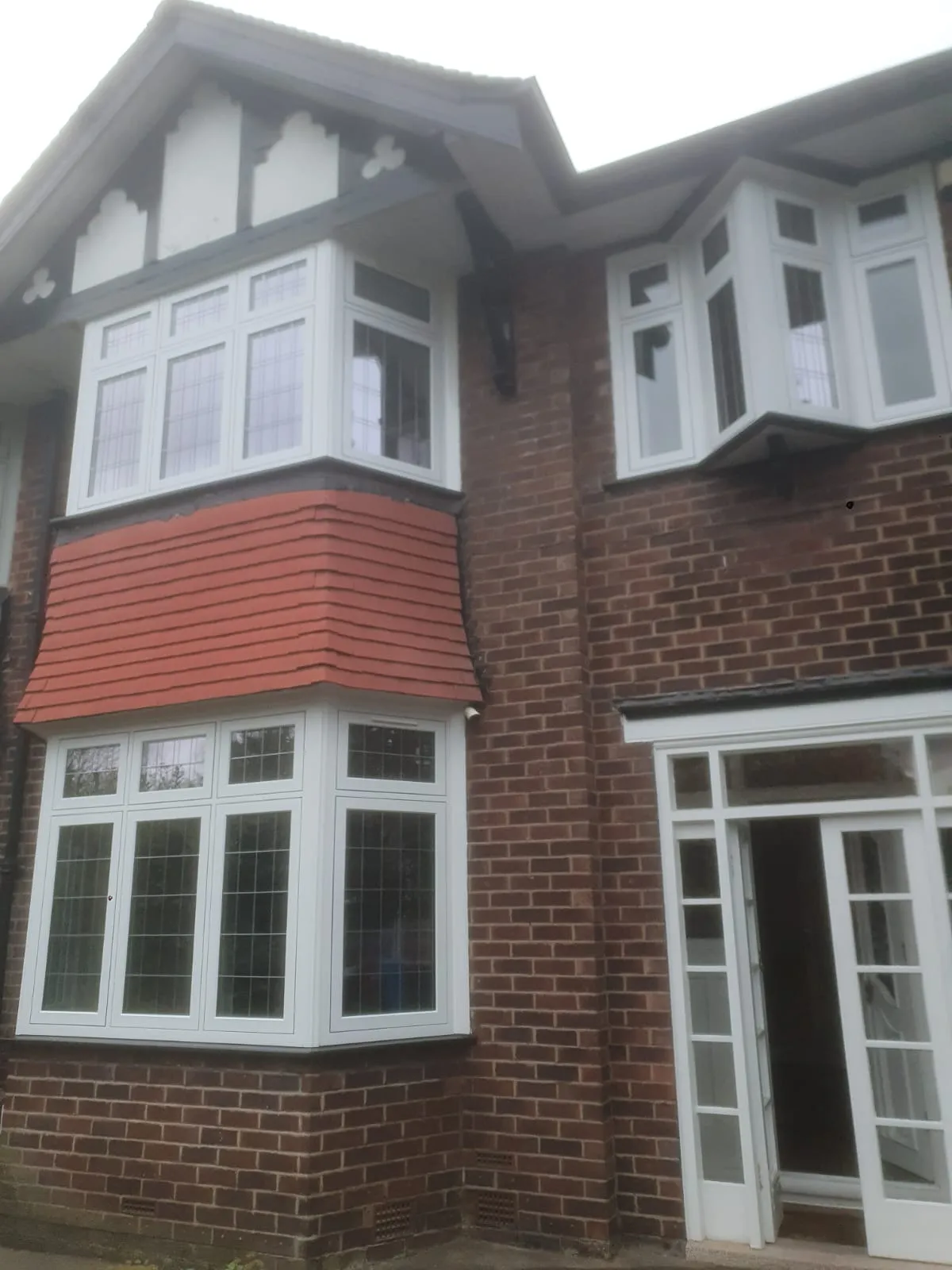 White leaded bay windows with Tudor-style detailing on a 1930s semi in Manchester