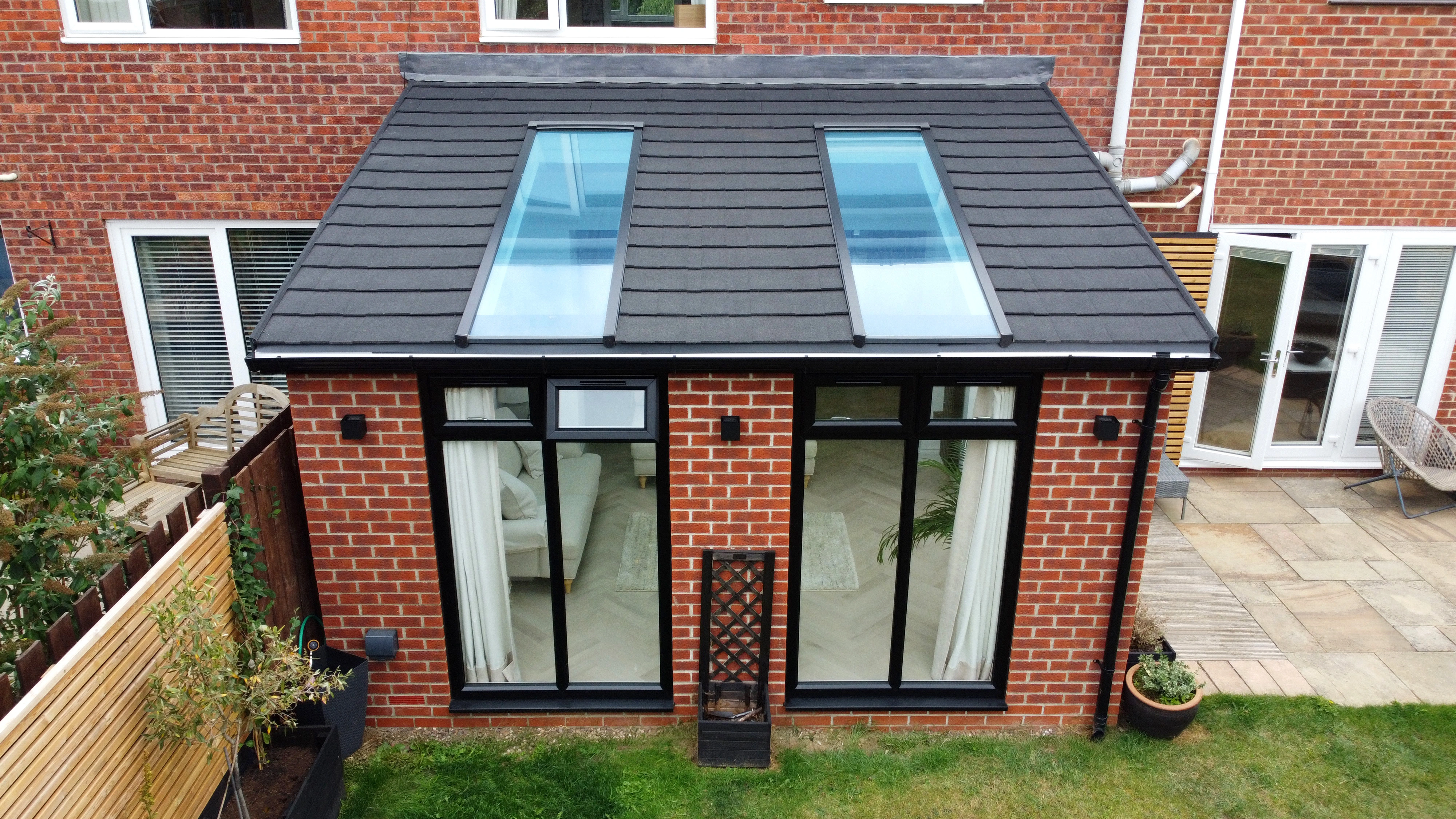 Brick garden room with anthracite grey frames and twin roof skylights